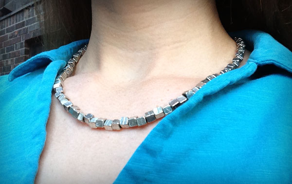 Close-up of Julia wearing cubed silver necklace