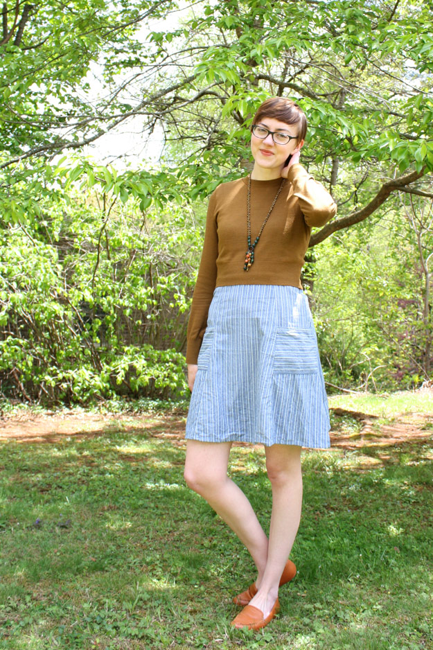 Leah smiling in blue dress and brown sweater