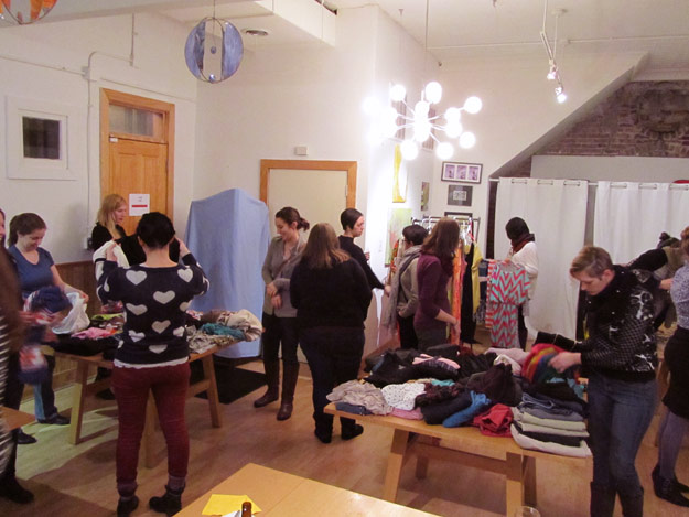 Women browsing tables of clothing