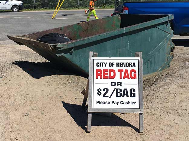 Small trash dumpster with $2 fee sign